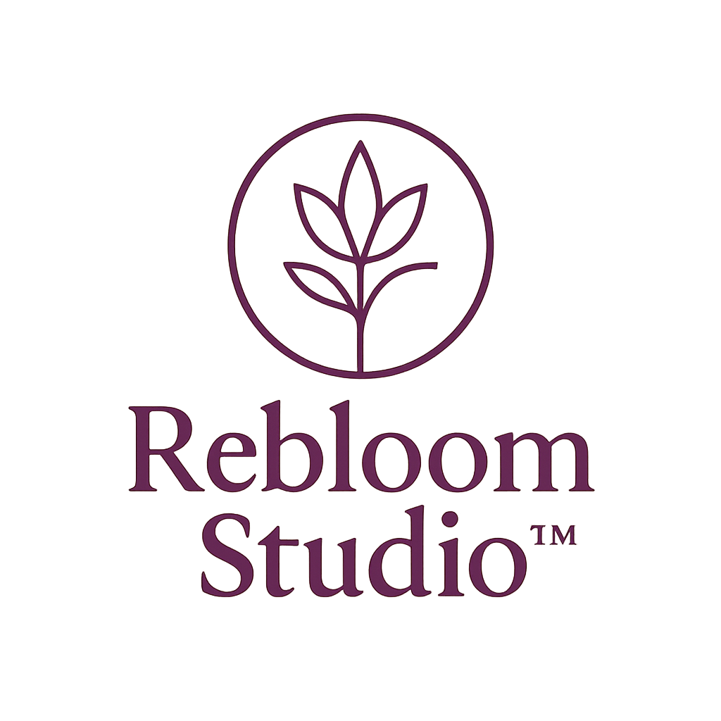 The Rebloom Studio™ logo features a circular emblem with a soft plum-rose plant symbol above the brand name in an elegant serif font. Displayed on a transparent background, the design conveys warmth, grace, and feminine creativity.